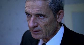 Movie still from “The Secret of the Grain” (2007), directed by Abdellatif Kechiche – An older man wearing a suit and tie; Close Up shot, Over the shoulder angle