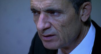 Movie still from “The Secret of the Grain” (2007), directed by Abdellatif Kechiche – An older man looking into the distance with a serious look on his face; Close Up shot, Over the shoulder angle