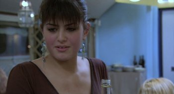 Movie still from “The Secret of the Grain” (2007), directed by Abdellatif Kechiche – A young woman is holding a bottle of wine; Close Up shot, Over the shoulder angle