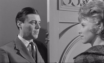 Movie still from “The Servant” (1963), directed by Joseph Losey – A black and white photo of a man and a woman; Medium shot, Over the shoulder angle