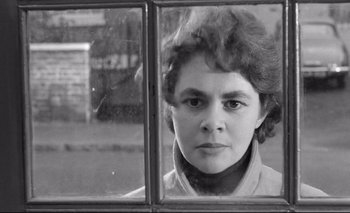 Movie still from “The Servant” (1963), directed by Joseph Losey – A black - and - white photo of a woman looking out of a window; Close Up shot, Over the shoulder angle