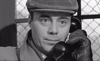 Movie still from “The Servant” (1963), directed by Joseph Losey – A black and white photo of a man on a phone; Close Up shot, High angle