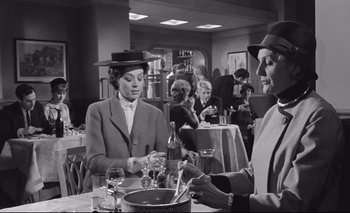 Movie still from “The Servant” (1963), directed by Joseph Losey – An old black and white photo of a man and a woman at a restaurant; Medium shot, Low angle