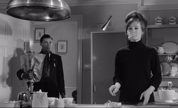Movie still from “The Servant” (1963), directed by Joseph Losey – A man and a woman are standing in front of a mirror; Medium shot, Over the shoulder angle