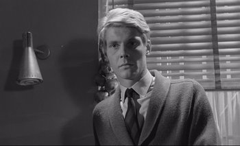 Movie still from “The Servant” (1963), directed by Joseph Losey – Black and white photograph of a man in a suit; Close Up shot, Low angle