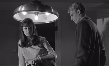 Movie still from “The Servant” (1963), directed by Joseph Losey – A man and a woman standing in front of a mirror; Medium shot, Low angle