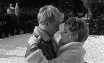 Movie still from “The Servant” (1963), directed by Joseph Losey – A man and a woman embracing each other in the snow; Close Up shot, High angle