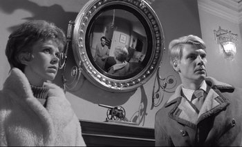 Movie still from “The Servant” (1963), directed by Joseph Losey – Two people are standing in front of a mirror; Close Up shot, Over the shoulder angle