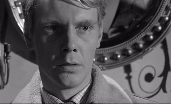 Movie still from “The Servant” (1963), directed by Joseph Losey – Black and white photograph of a man in front of a mirror; Close Up shot, Low angle