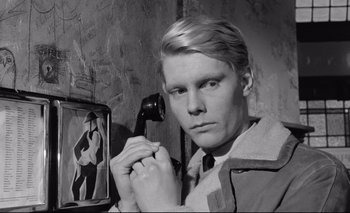 Movie still from “The Servant” (1963), directed by Joseph Losey – A young man holding a phone up to his face; Close Up shot, High angle