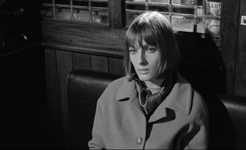 Movie still from “The Servant” (1963), directed by Joseph Losey – A black and white photo of a woman sitting in front of a window; Close Up shot, High angle