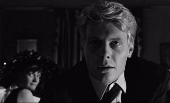 Movie still from “The Servant” (1963), directed by Joseph Losey – Black and white photograph of a man in a suit; Close Up shot, Over the shoulder angle