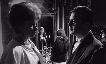 Movie still from “The Servant” (1963), directed by Joseph Losey – A man and a woman standing next to each other; Medium shot, Over the shoulder angle