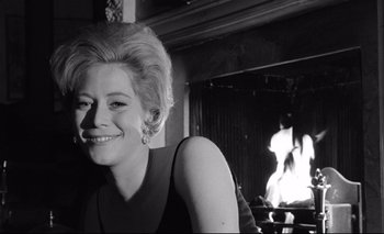 Movie still from “The Servant” (1963), directed by Joseph Losey – A black - and - white photo of a woman in front of a fireplace; Close Up shot, Low angle