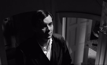 Movie still from “The Servant” (1963), directed by Joseph Losey – Black and white photograph of a man in a suit; Close Up shot, Low angle