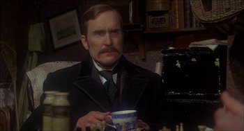 Movie still from “The Seven-Per-Cent Solution” (1976), directed by Herbert Ross – A man in a suit and tie holding a coffee cup; Close Up shot, Over the shoulder angle