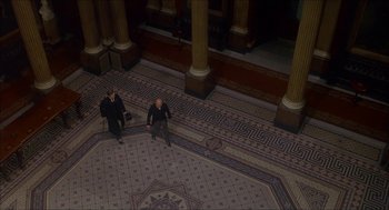 Movie still from “The Seven-Per-Cent Solution” (1976), directed by Herbert Ross – Two men sitting on the floor of a building; Extreme Wide shot, Overhead angle