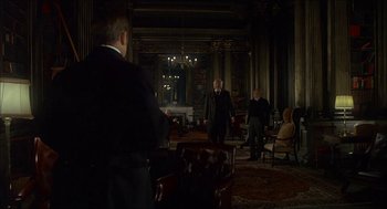 Movie still from “The Seven-Per-Cent Solution” (1976), directed by Herbert Ross – A group of men standing in a living room; Wide shot, Low angle