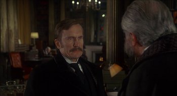 Movie still from “The Seven-Per-Cent Solution” (1976), directed by Herbert Ross – A man in a suit and tie talking to another man in a suit and tie; Close Up shot, Over the shoulder angle