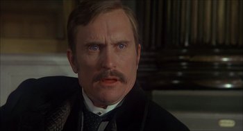 Movie still from “The Seven-Per-Cent Solution” (1976), directed by Herbert Ross – A person wearing a suit and tie; Close Up shot, Over the shoulder angle