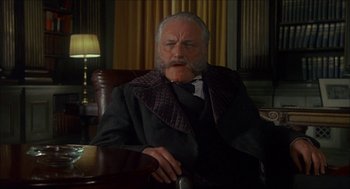 Movie still from “The Seven-Per-Cent Solution” (1976), directed by Herbert Ross – An older man sitting in a chair in a room; Close Up shot, Low angle