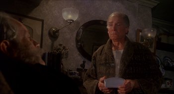 Movie still from “The Seven-Per-Cent Solution” (1976), directed by Herbert Ross – An older man holding a nintendo wii game controller in front of a mirror; Medium shot, Over the shoulder angle