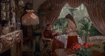 Movie still from “The Seven-Per-Cent Solution” (1976), directed by Herbert Ross – A painting of a man and a woman in a living room; Wide shot, High angle