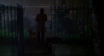 Movie still from “The Seven-Per-Cent Solution” (1976), directed by Herbert Ross – A man and a dog are standing in the dark; Wide shot, Over the shoulder angle