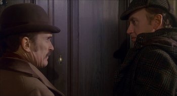 Movie still from “The Seven-Per-Cent Solution” (1976), directed by Herbert Ross – Two men in hats are standing in front of a door; Close Up shot, Over the shoulder angle