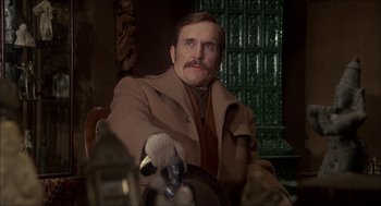 Movie still from “The Seven-Per-Cent Solution” (1976), directed by Herbert Ross – A man in a brown coat sitting in a chair; Close Up shot, Low angle