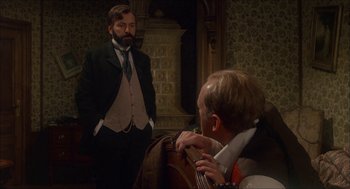 Movie still from “The Seven-Per-Cent Solution” (1976), directed by Herbert Ross – A man in a suit and tie looking at another man in a suit and tie; Medium shot, Over the shoulder angle