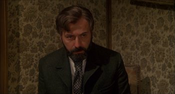 Movie still from “The Seven-Per-Cent Solution” (1976), directed by Herbert Ross – A man in a suit and tie looking at the camera; Close Up shot, Low angle