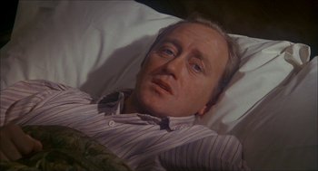 Movie still from “The Seven-Per-Cent Solution” (1976), directed by Herbert Ross – A man laying in a bed looking at the camera; Close Up shot, High angle
