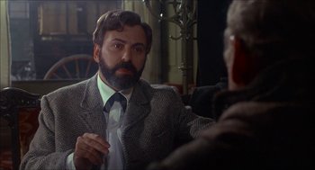 Movie still from “The Seven-Per-Cent Solution” (1976), directed by Herbert Ross – A man in a suit and tie talking to another man in a suit and tie; Close Up shot, Over the shoulder angle