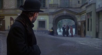 Movie still from “The Seven-Per-Cent Solution” (1976), directed by Herbert Ross – A man wearing a black hat and a black coat; Wide shot, Over the shoulder angle
