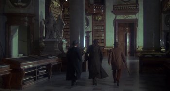 Movie still from “The Seven-Per-Cent Solution” (1976), directed by Herbert Ross – A group of men walking through a library; Wide shot, Low angle