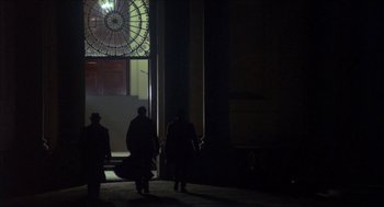 Movie still from “The Seven-Per-Cent Solution” (1976), directed by Herbert Ross – A group of people walking down a street at night; Wide shot, Low angle