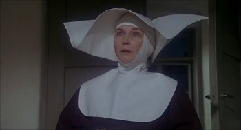 Movie still from “The Seven-Per-Cent Solution” (1976), directed by Herbert Ross – A woman wearing a nun's hat in a dark room; Close Up shot, Low angle