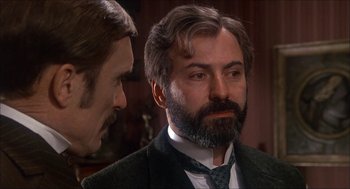 Movie still from “The Seven-Per-Cent Solution” (1976), directed by Herbert Ross – A man in a suit and tie next to another man in a suit and tie; Close Up shot, Over the shoulder angle