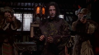 Movie still from “The Shadow” (1994), directed by Russell Mulcahy – A man wearing a robe standing next to a lamp; Medium shot, Low angle