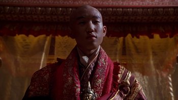 Movie still from “The Shadow” (1994), directed by Russell Mulcahy – A man wearing a red robe and a gold and red tie; Close Up shot, Low angle