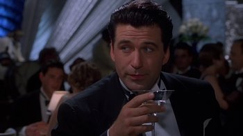 Movie still from “The Shadow” (1994), directed by Russell Mulcahy – A person holding a glass of wine; Close Up shot, Low angle