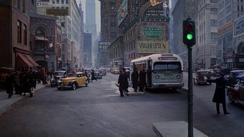 Movie still from “The Shadow” (1994), directed by Russell Mulcahy – A city street filled with lots of traffic; Extreme Wide shot, High angle