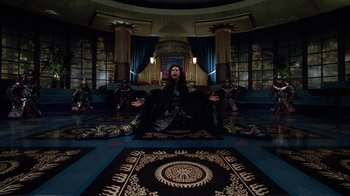 Movie still from “The Shadow” (1994), directed by Russell Mulcahy – A man sitting on the floor of a room; Wide shot, High angle