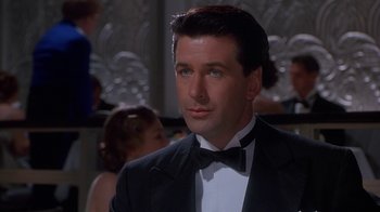 Movie still from “The Shadow” (1994), directed by Russell Mulcahy – A person wearing a suit and a bow tie; Close Up shot, Low angle