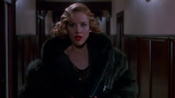 Movie still from “The Shadow” (1994), directed by Russell Mulcahy – A woman with blonde hair wearing a black fur coat; Close Up shot, Low angle