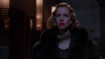 Movie still from “The Shadow” (1994), directed by Russell Mulcahy – A woman with red lipstick wearing a black fur coat; Close Up shot, Low angle