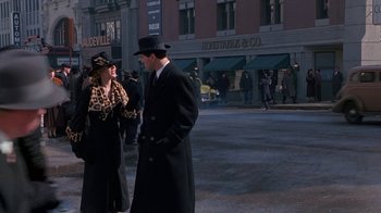 Movie still from “The Shadow” (1994), directed by Russell Mulcahy – A man and a woman standing on the sidewalk; Wide shot, Over the shoulder angle