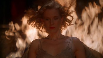 Movie still from “The Shadow” (1994), directed by Russell Mulcahy – A beautiful woman with long blonde curly hair; Close Up shot, Low angle