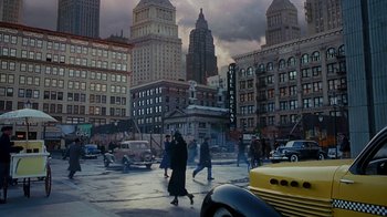 Movie still from “The Shadow” (1994), directed by Russell Mulcahy – A group of people walking across a street in a city; Extreme Wide shot, High angle